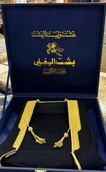 Navy Albaghli presentation box holding a black bisht with gold zari