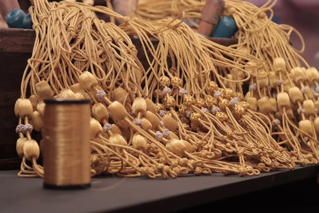Gold zari tassels and a spool of gold thread